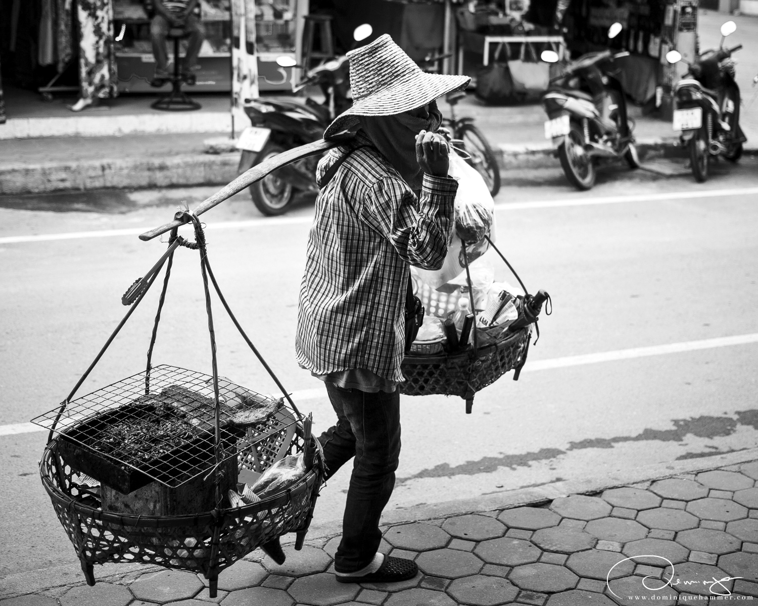 Eine Frau mit einem kleinen tragbaren Grill auf der Stra&szlig;e von Koh Samui von Fotograf Dominique Hammer