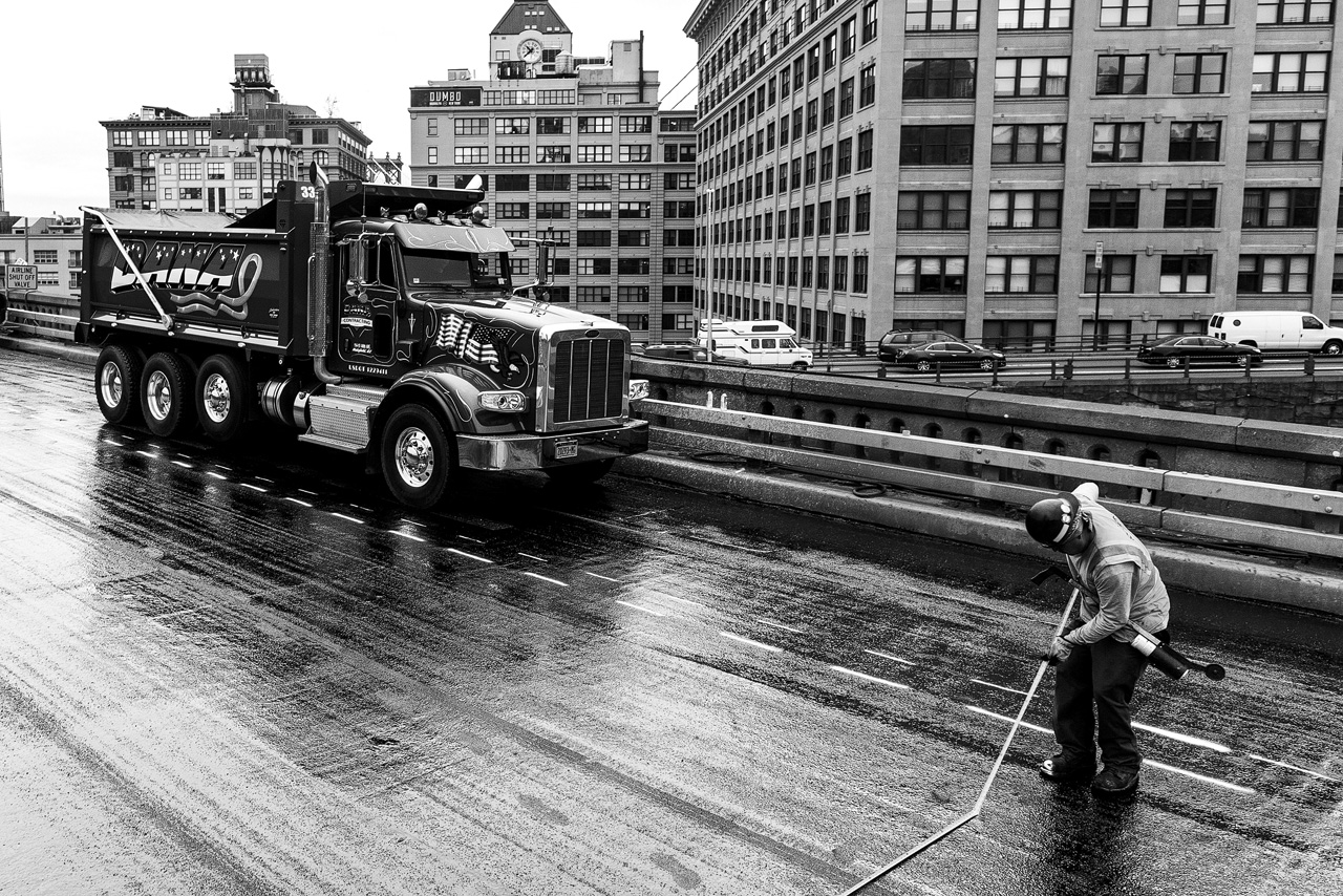 Ein Arbeiter bei einem Truck auf der Brooklyn Bridge in New York von Fotograf Dominique Hammer