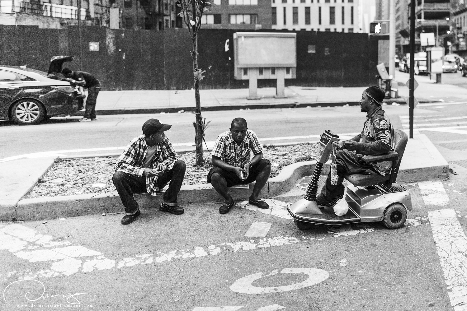 Drei M&auml;nner sitzen auf dem gehsteig in Manhattan, New York von Fotograf Dominique Hammer